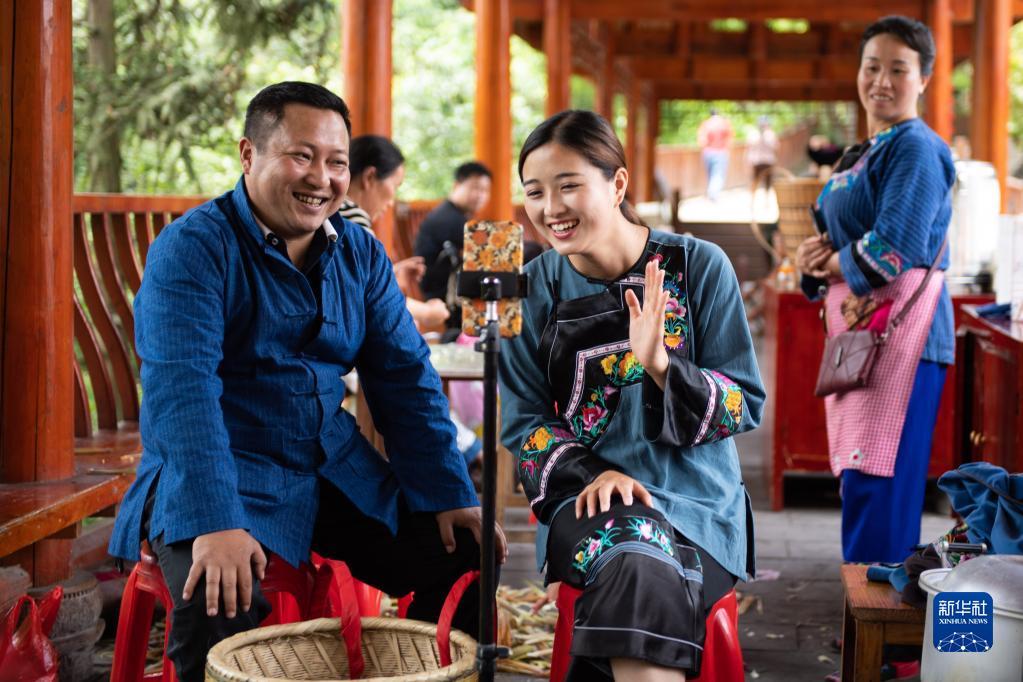 在湖南湘西十八洞村，十八洞村扶贫队长麻辉煌（左）与返乡老员工施林娇（中）一起直播推销土特产（2020年5月15日摄）。新华社记者 陈思汗 摄